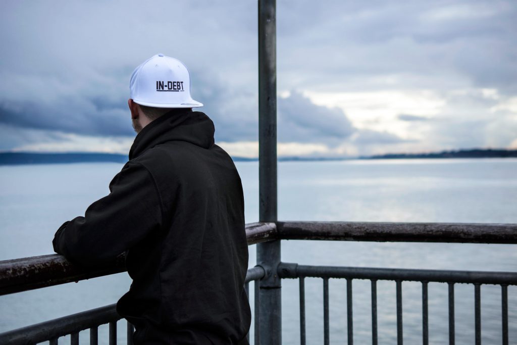 In-Debt Clothing: White cap with black logo